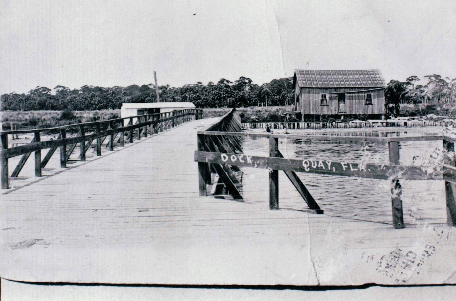 Old photo of a boardwalk with a building in the distance