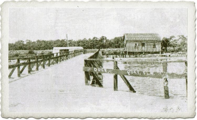 Old photo of a boardwalk with a building in the distance